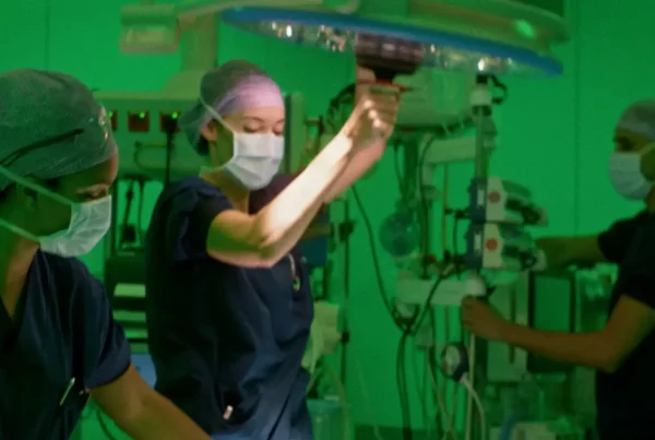 Groep artsen aan het werk in de operatiekamer in een groen verlichte kamer